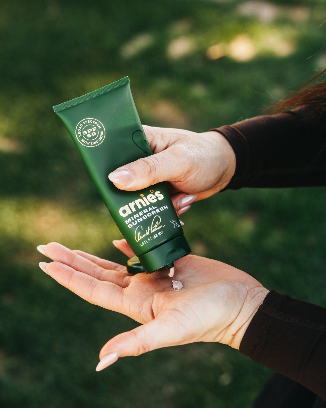 Arnie's Mineral Face Sunscreen squeezed into a hand on the course.